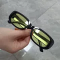 Detail view of retro square sunglasses featuring black frames and yellow tinted lenses - Black Frame Yellow Lens