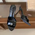 Close-up detail of elegant black patent leather peep-toe stiletto heels on a glass shelf - 35 / Black