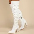 Close-up of white pleated over-the-knee boots with a stable chunky high heel design. - 35 / White