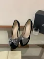 Nahaufnahme eleganter schwarzer Stilettos mit einem funkelnden Strass-Schleifendetail. - 34 / Schwarz