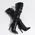 Close-up detail of black over-the-knee boots featuring a slouchy design and high stiletto heels - 35 / Black