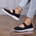 Dettaglio dei sandali bassi elastici intrecciati neri da donna indossati sui piedi - 35 / Nero