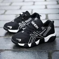 Side view of black boys' running shoes with white fashion accents on stone tiles - 28 / Single Mesh Version / Black and White