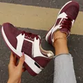 Detail view of stylish burgundy and white lace-up casual sneakers with gold accents - 38 / Burgundy