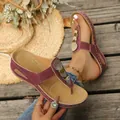 Detailed view of burgundy thong sandals with rhinestone discs and white stitching - 36 / Burgundy
