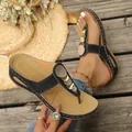 Detail shot of women's black flip-flop sandals featuring gold decorative circles - 36 / Black