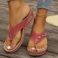 Gros plan de sandales compensées roses pour femmes avec motif perforé et boucle décorative - 36 / Rouge