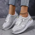 Detailed view of silver wedge sneakers with zipper accent and gold metallic heel trim - 38 / Silver