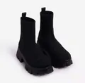 Close-up detail of black knit sock boots with chunky lug sole and ribbed cuff - 35 / Black