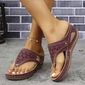 Detail view of burgundy wedge thong sandals with laser-cut floral patterns and rivets - Purple