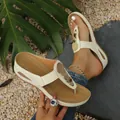 Close-up detail of comfortable cream beach flip-flop sandals with decorative gold metal disks. - 36 / Off White