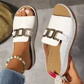 Gros plan de sandales blanches à semelles compensées pour femmes avec boucle dorée - 36 / Blanc