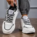 Vista ravvicinata di sneakers bianche spesse da uomo con accenti neri e lacci - 39 / bianco e nero