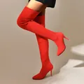 Botas altas rojas de punto elástico con tacones de aguja sobre una modelo en estudio. - 36 / Rojo