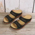 Paar zwarte dames wedge sandalen met uitgesneden bandjes op een rustieke houten achtergrond - 36 / Zwart
