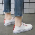 Casual women's white faux leather sneakers with distinctive red heel tab detail and laces - 35 / White (With Red)