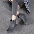 Detail view of retro grey ankle boots featuring cross-strap design on soft textured leather - 38 / Gray