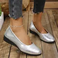 Close-up detail of silver women's wedge shoes with crocodile pattern texture on wooden floor - 36 / Silver