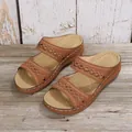 Gros plan de sandales à talons compensés marron avec broderies et coutures blanches - 35 / Brun Foncé