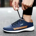 Men's stylish navy blue waterproof leather sneaker with tan accents shown in use. - 38 / Blue