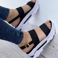 Primer plano de sandalias de plataforma negras y blancas elegantes en los pies de una mujer. - Negro