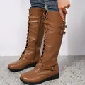 Side detail of brown lace-up knee-high knight boots with buckle straps and flat heel. - Yellow Brown