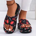 Close-up of black platform slippers with red lip and 'Love!' script pattern. - 36 / Lipstick Printed / Red