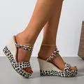 Detailed view of women's leopard print wedge sandals with buckle straps. - 36 / Leopard Print