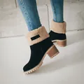 Side view of black suede snow boots with sherpa trim and chunky heels on a model. - 35 / Black