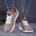 Detalle de zapatillas de ante topo con cordones blancos en un entorno callejero - 36 / Caqui
