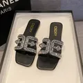 Elegant black flat slippers featuring rhinestone cross-straps and a modern square toe design. - 35 / Black