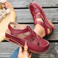 Detail view showing the textured red leather and hollow-out design of women's wedge sandals. - 36 / Red