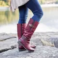 Detailed view of burgundy knee-high knight boots with buckle straps on a rocky background - 35 / Burgundy