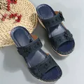 Detailed view of blue wedge sandals with floral accents and decorative white stitching. - 36 / Black