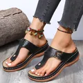 Detalle de chanclas de cuña negras para mujer con hebilla de metal y costuras blancas. - Negro