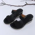 Detailed view of black wedge sandals featuring floral appliques and sparkling rhinestones. - 35 / Black