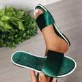 Close-up of emerald green velvet flat slides with white trim and satin finish. - 35 / Green