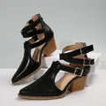 Detailed macro view of black pointed toe boots with multiple silver buckle straps. - 36 / Black
