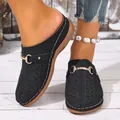 Detailed close-up view of women's black hollowed-out wedge mules with a gold buckle - 36 / Black