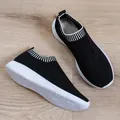 Seitenansicht atmungsaktiver schwarzer Fly-Knit-Sneaker für Damen auf Holzboden - 35 / Schwarz