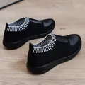 Dettaglio ravvicinato di sneaker nere in maglia traspirante da donna con collo a coste - pois neri