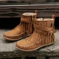 Detail view of brown suede fringe boots with studs and moccasin stitching on stone step. - 36 / Brown