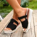 Close-up of women wearing stylish black wedge sandals with braided trim and platform sole. - 38 / Black