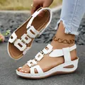 Close-up detail of stylish white wedge sandals with gold metal buckles and comfort straps - White