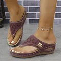 Close-up of maroon wedge thong sandals with laser-cut patterns and gold buckle - 36 / Burgundy