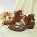 Close-up detail of vintage floral embroidery on brown Western-style square toe ankle boots - 38 / Tan