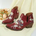 Detail of vintage red Western boots with floral embroidery, square toe, and chunky heel design. - 35 / Burgundy