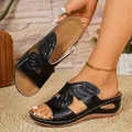 Close-up detail of black wedge sandals with unique wing-shaped cutout design and white stitching - 38 / Black