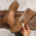 Close-up detail of brown women's tassel loafers featuring cream contrast stitching - Dark Brown