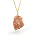 Detailed view of wire wrapped natural orange raw crystal stone pendant necklace - Sunstone (Wire Wrapped) / Gold